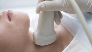 A woman is having a private ultrasound of the thyroid in London to check for any pathologies