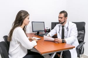 a patint is discussing the results of her tests with a doctor in his office